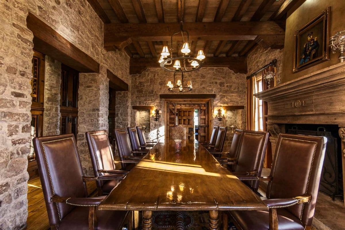 Finished stone walls and fireplace surrounding a furnished board room