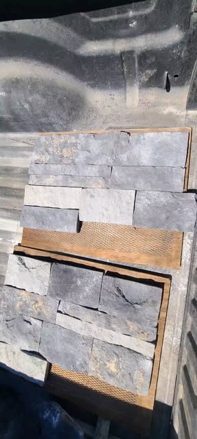 Grey stacked stone panels laid out on the shop floor before installation